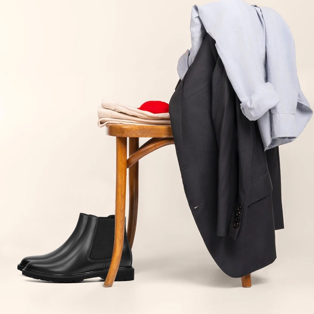 Schwarze Chelsea Boots neben Anzug und Hemd – stilvolle Schuhe, die größer machen für den Herbst.