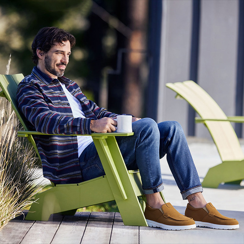 Man relaxing outdoors with coffee, wearing casual brown elevator shoes in Australia