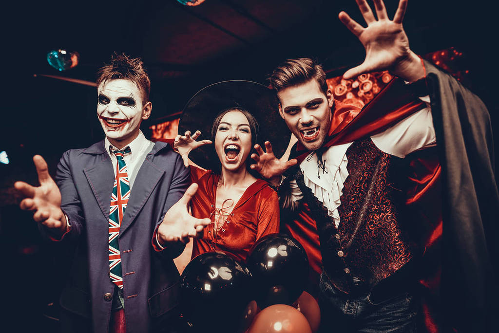 Halloween 2025 Kostüme in Deutschland – Gruppe von Freunden verkleidet als Vampir, Hexe und Joker bei einer festlichen Feier.