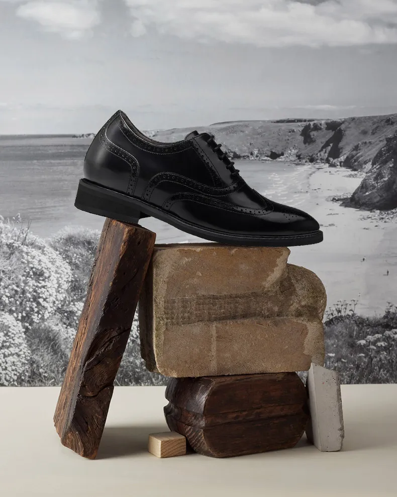 Handcrafted wingtip brogue elevator shoes for men with 8 cm height increase, architectural design display.