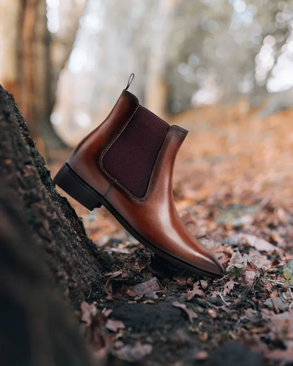 Brown leather elevator Chelsea boots for men with 7 cm height boost, shown on autumn leaves in Australia.