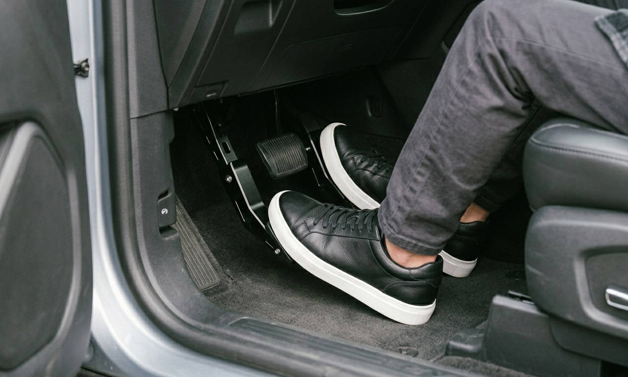 Close-up of high-quality car pedal extenders installed on a vehicle's gas and brake pedals to assist shorter drivers.
