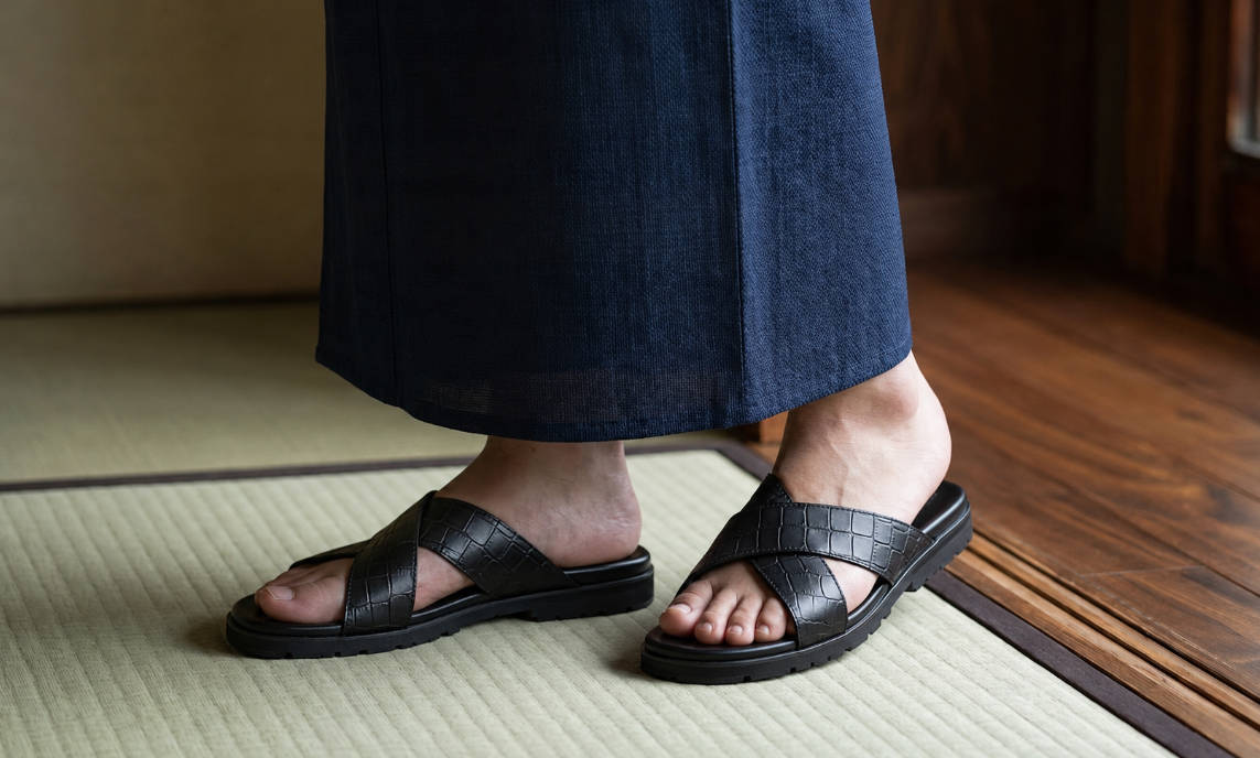 ネイビーの浴衣に高品質な黒のクロスストラップサンダルを合わせたメンズ着こなし