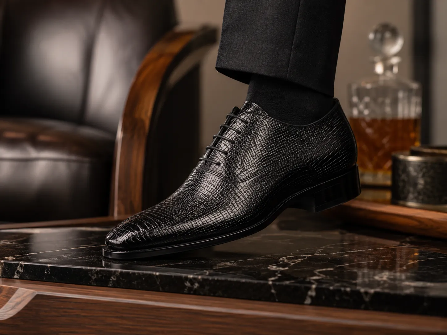 A close-up of a gentleman wearing premium black lizard leather Oxford shoes with a finely textured scale pattern.